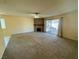 Spacious living room with a brick fireplace, carpet flooring, and sliding glass door to the patio at 6412 Churchfield Blvd, Las Vegas, NV 89103