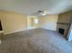 Expansive living room featuring carpet flooring and a classic brick fireplace at 6412 Churchfield Blvd, Las Vegas, NV 89103