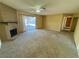 Spacious living room with a brick fireplace, carpet flooring, and a door to the hallway at 6412 Churchfield Blvd, Las Vegas, NV 89103