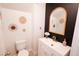 Stylish half-bathroom with vanity, mirror, decor and neutral tones, creating a fresh and clean aesthetic at 7403 Benlomond Ave, Las Vegas, NV 89179