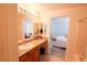 Full bathroom with a vanity, a well-lit mirror and a view to the main bedroom at 7403 Benlomond Ave, Las Vegas, NV 89179