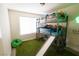Bright bedroom featuring a bunk bed with a slide and playful green rug at 7403 Benlomond Ave, Las Vegas, NV 89179