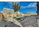 Landscaped backyard featuring stone pavers, desert plants, small trees and a cozy fire pit area at 9940 Heather Moore Ave, Las Vegas, NV 89166