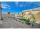 Landscaped backyard featuring stone pavers, desert plants, small trees and a cozy fire pit area at 9940 Heather Moore Ave, Las Vegas, NV 89166