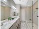 Bright bathroom showcasing a dual sink vanity with white marble countertops and a spacious glass shower at 9940 Heather Moore Ave, Las Vegas, NV 89166