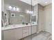 Bright bathroom featuring a dual sink vanity with marble countertops, cabinet storage, and a glass shower at 9940 Heather Moore Ave, Las Vegas, NV 89166