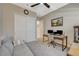 This bedroom features a neutral color palette, a ceiling fan, and is furnished with a work station and a comfortable sofa at 9940 Heather Moore Ave, Las Vegas, NV 89166