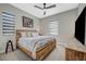 Cozy bedroom featuring a rustic wooden bed frame, modern ceiling fan, and neutral-toned walls at 9940 Heather Moore Ave, Las Vegas, NV 89166
