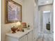 Bright hallway with a console table, decorative items, artwork, and doorways to other rooms at 9940 Heather Moore Ave, Las Vegas, NV 89166