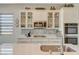 Kitchen features stainless steel appliances, elegant tile backsplash, and white cabinets at 9940 Heather Moore Ave, Las Vegas, NV 89166