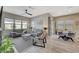 Comfortable living room boasts hardwood floors, gray sofas, ceiling fan, and a dining area at 9940 Heather Moore Ave, Las Vegas, NV 89166