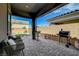 Covered patio featuring brick pavers, outdoor seating, a grill and desert landscaping perfect for relaxing and entertaining at 9940 Heather Moore Ave, Las Vegas, NV 89166
