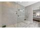Walk-in shower with gray tiling, built-in shelf, and clear glass, complemented by gray tiled floors at 9940 Heather Moore Ave, Las Vegas, NV 89166