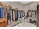 Well-organized walk-in closet featuring hanging racks, shoe shelves, and a decorative stool at 9940 Heather Moore Ave, Las Vegas, NV 89166