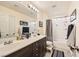 Bathroom features a double sink vanity, neutral tile flooring, and a bathtub with a shower at 10316 Northern Hills Ave, Las Vegas, NV 89166