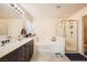 Bright bathroom featuring double sinks, a soaking tub, and a separate glass-enclosed shower at 10316 Northern Hills Ave, Las Vegas, NV 89166