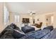 Spacious living room with large sectional sofa, ceiling fan, and bright windows with plantation shutters at 10316 Northern Hills Ave, Las Vegas, NV 89166