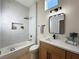 Modern bathroom featuring stylish vanity, bathtub, and marble-look tile surround at 10412 Button Willow Dr, Las Vegas, NV 89134