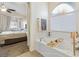 Bright bathroom features a large soaking tub, and neutral color palette, and access to the main bedroom at 10638 La Spezia Way, Las Vegas, NV 89141