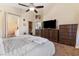 Bedroom with ceiling fan, archway to bathroom, walk-in closet and view of the kitchen at 10638 La Spezia Way, Las Vegas, NV 89141