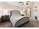 Neutral bedroom with plush carpet, ceiling fan, and archway to bathroom at 10638 La Spezia Way, Las Vegas, NV 89141