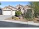 Inviting home with a three-car garage, desert landscaping, and an American flag at 10638 La Spezia Way, Las Vegas, NV 89141