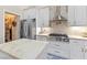 Bright kitchen featuring stainless steel appliances, marble countertops, and white custom cabinetry at 10638 La Spezia Way, Las Vegas, NV 89141