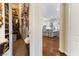 Open-concept view from walk-in closet into the bright kitchen with white cabinets and wood flooring at 10638 La Spezia Way, Las Vegas, NV 89141