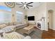 Cozy living room featuring hardwood floors, a stylish fireplace, and large windows for natural light, perfect for relaxing at 10638 La Spezia Way, Las Vegas, NV 89141