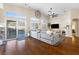 Spacious living room featuring hardwood floors, fireplace, and large windows that offer a view of the backyard pool at 10638 La Spezia Way, Las Vegas, NV 89141