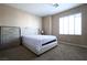 Cozy bedroom with a tufted headboard, large window, and neutral carpet at 10657 Blue Nile Ct, Las Vegas, NV 89144