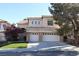 Two-story home with a three-car garage, desert landscaping, and a red tile roof at 10657 Blue Nile Ct, Las Vegas, NV 89144