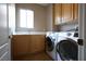 Functional laundry room with built-in cabinets, a utility sink, and modern appliances at 10657 Blue Nile Ct, Las Vegas, NV 89144