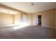Spacious and sunlit living room features neutral paint, plush carpeting, and arched doorway at 10657 Blue Nile Ct, Las Vegas, NV 89144