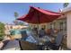 Inviting backyard patio with a pool, seating under a red umbrella, and landscaped surroundings at 1349 Foxglove Dr, Las Vegas, NV 89142