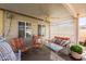 Relaxing covered patio area featuring ceiling fan, lounge seating with throw pillows, and wicker furniture at 1349 Foxglove Dr, Las Vegas, NV 89142