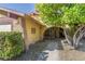 Charming home exterior with arched entryway, a well-maintained lawn, and mature tree providing shade at 1349 Foxglove Dr, Las Vegas, NV 89142