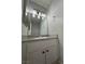 Bathroom vanity with gray countertop, modern lighting, and white cabinets, creating a clean and functional space at 1460 Hialeah Dr # D, Las Vegas, NV 89119