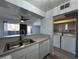 Modern kitchen with stainless sink, dishwasher, white cabinets, and laundry access at 1460 Hialeah Dr # D, Las Vegas, NV 89119