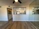 Living room with wood-look floors, ceiling fan, and open view to kitchen and laundry area at 1460 Hialeah Dr # D, Las Vegas, NV 89119