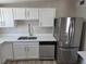 Bright kitchen featuring stainless steel refrigerator and dishwasher, white cabinets, and a modern faucet at 1642 Palma Vista Ave, Las Vegas, NV 89169