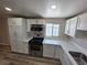 White kitchen cabinets with stainless steel appliances and wood-look flooring at 1642 Palma Vista Ave, Las Vegas, NV 89169