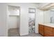Bright bathroom leading into a closet featuring wood-look floors, neutral walls, and white paint at 1701 E Katie Ave # 57, Las Vegas, NV 89119