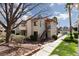 A condo featuring an exterior staircase to the unit's entrance, grass, tree, and desert landscaping at 1701 E Katie Ave # 57, Las Vegas, NV 89119