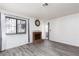 Bright living room featuring wood-look flooring and a brick fireplace with large window for natural light at 1701 E Katie Ave # 57, Las Vegas, NV 89119