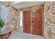 Stone entryway with wooden double doors and a glass block window at 1904 Chapman Dr, Las Vegas, NV 89104