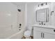 Bright bathroom features a shower-tub combo, white tile and vanity with modern fixtures at 2160 Point Mallard Dr, Henderson, NV 89012
