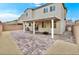 The spacious backyard boasts a covered patio, brick pavers, a barbecue grill, and a seating area at 2205 Stone Well Rd, North Las Vegas, NV 89031