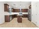 Modern kitchen boasts stainless steel appliances, quartz countertops, an island, and ample cabinet space at 2205 Stone Well Rd, North Las Vegas, NV 89031