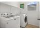 Laundry room features a washer and dryer, overhead storage, and a window at 2205 Stone Well Rd, North Las Vegas, NV 89031